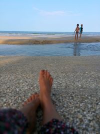 People at beach against sky