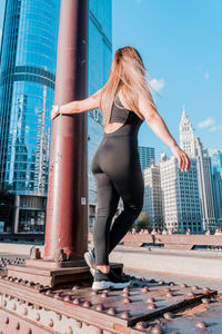 Woman with umbrella against buildings in city