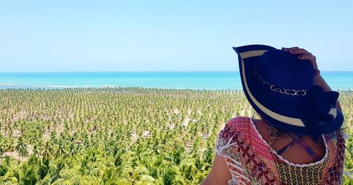 Woman wearing hat against sea against clear sky