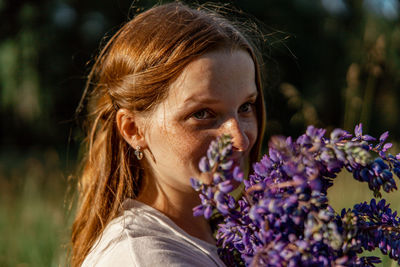 Close up portrait of young beautiful redhead woman with freckles, wearing white dress