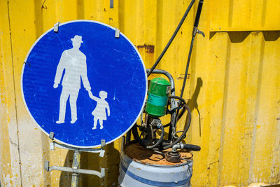 Close-up of bicycle sign on yellow wall