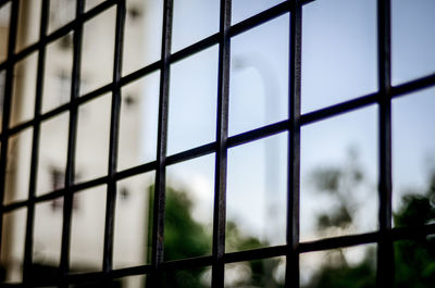 Close-up of metal grate against sky