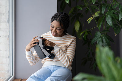 Afro woman blogger hold virtual reality glasses make video blog of interacting with 3d simulation