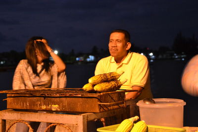 People sitting at market stall at night