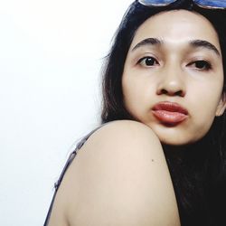 Close-up portrait of a young woman over white background