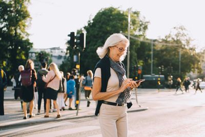 Rear view of people walking on street in city