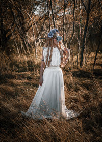 Woman standing by tree in forest