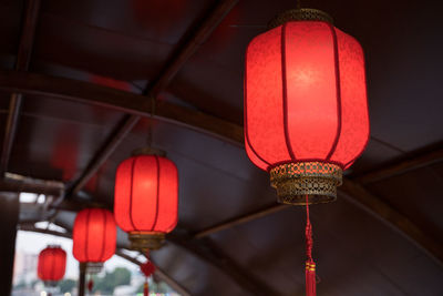 Low angle view of illuminated lanterns hanging in building