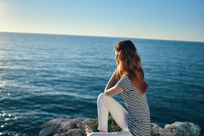 Rear view of woman looking at sea against sky