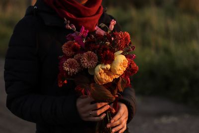 Midsection of person holding rose bouquet