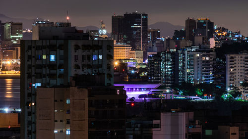 Illuminated buildings against sky at night