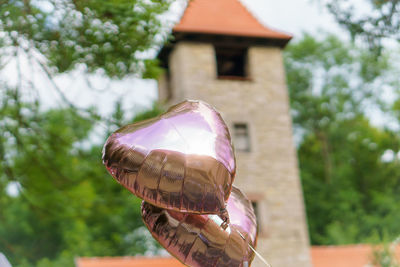 Close-up of hand holding umbrella against built structure