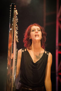 Portrait of smiling young woman playing at music concert