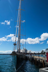 Sailboats moored in sea against sky