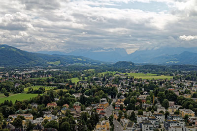 Aerial view of townscape and mountains against sky