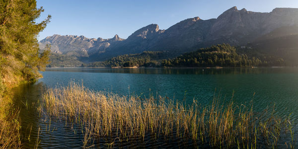 Scenic view of lake by mountains against sky