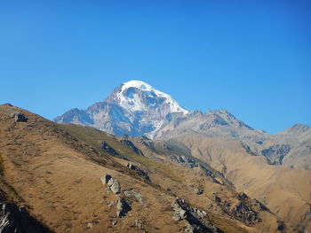 Scenic view of snowcapped mountains against clear blue sky