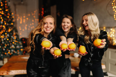 Happy women friends celebrate the christmas holiday at a party in the cozy kitchen of the house