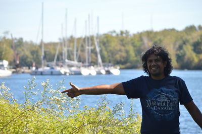 Young man holding plant in lake