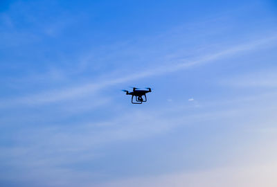 Low angle view of silhouette airplane against sky