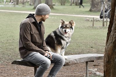 Man with dog sitting on bench