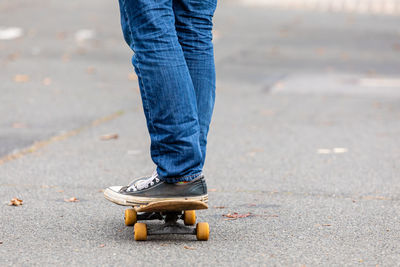 Low section of man skateboarding on road