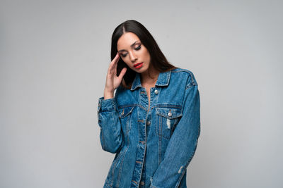 Young woman standing against wall