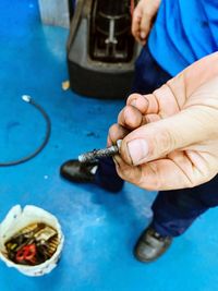 High angle view of man holding screw