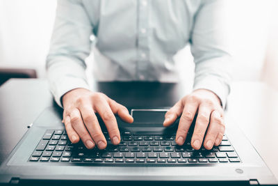 Midsection of man using laptop