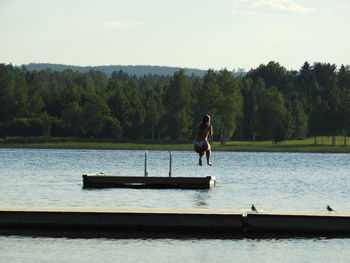 Man on lake against sky