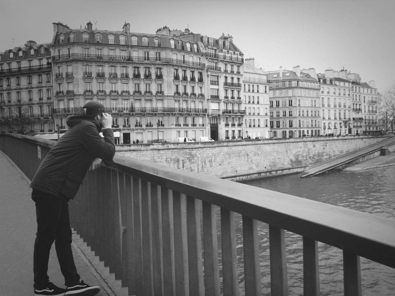 architecture, building exterior, built structure, water, lifestyles, men, railing, city, leisure activity, river, standing, rear view, building, full length, bridge - man made structure, canal, city life, day