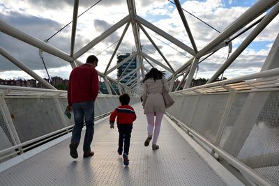 Full length rear view of family on footbridge