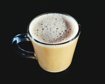 Close-up of tea cup on table against black background