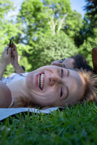 Portrait of smiling young woman lying on field