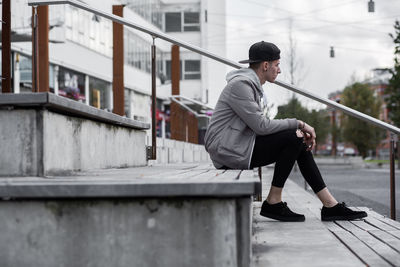 Full length of man sitting in city