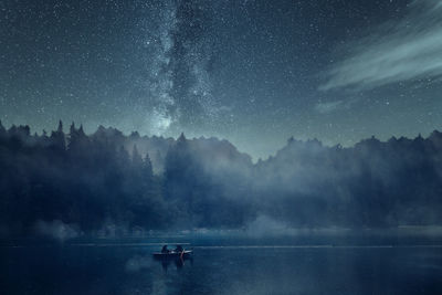 Scenic view of lake against sky at night