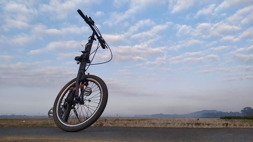 Bicycle on road against sky