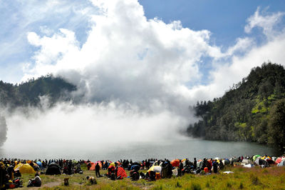 Panoramic shot of crowd on mountain against sky