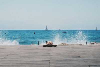 Tourist lying on boardwalk on beach