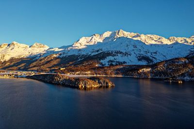 Scenic view of snowcapped mountains against clear blue sky