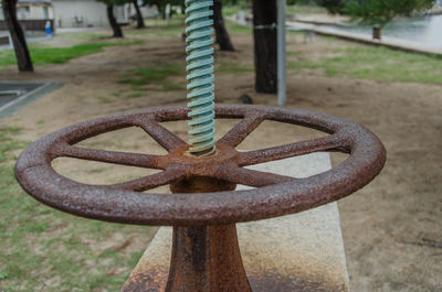 Close-up of rusty metal pole on field