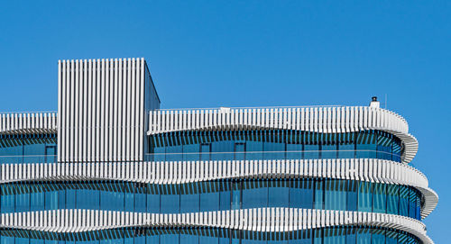 Low angle view of modern building against blue sky