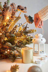 The girl's hands create a christmas decoration. the girl puts a candlestick with a candle 