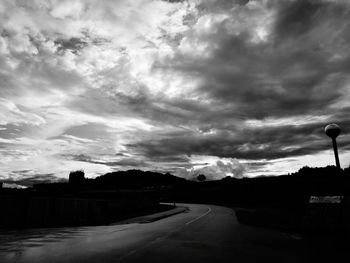 Empty road against cloudy sky