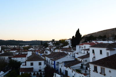 High angle view of houses in town against clear sky