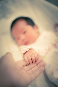 Close-up of cute baby hand on bed