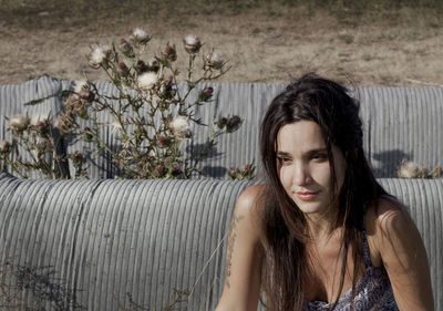 Beautiful young woman sitting on grass rolls outdoor