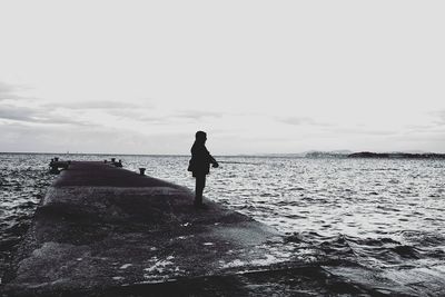 Silhouette of woman standing by sea