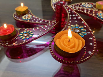 High angle view of illuminated candles on birthday cake