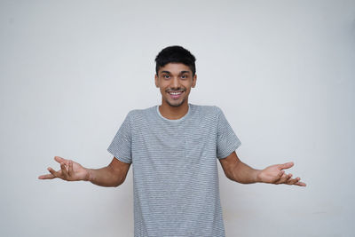 Portrait of young man standing against white background